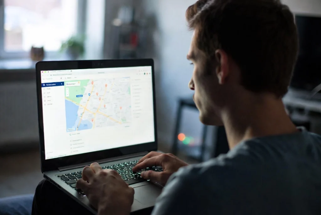 Freelancer centered at desk viewing Google Maps landing page on laptop screen in calm home office