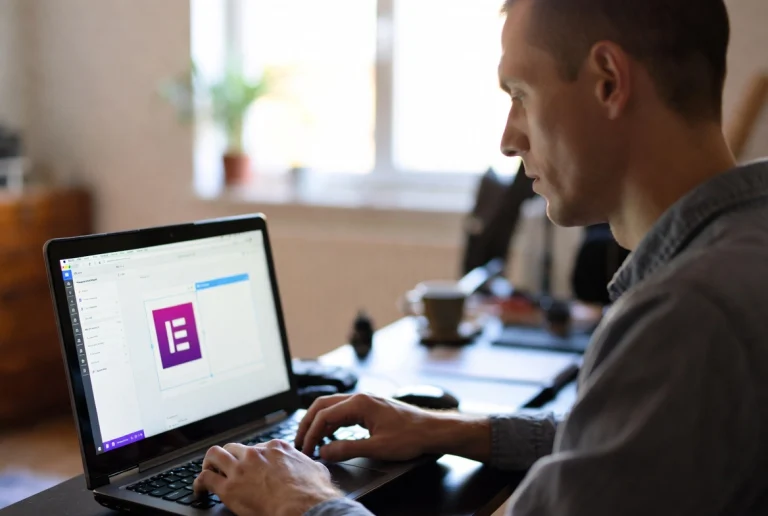 Professional man designing homepage banner on laptop with Elementor in home office